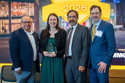Paige E. Allen holding an award, standing with the provost, vice president for research, and vice president for research development at the 2026 ARIA event.